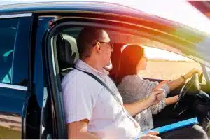 Man teaching woman how to drive attentively