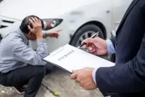 man holding car insurance contract while another man is worried about his car damages